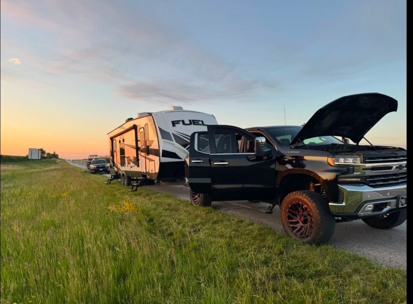 Truck and trailer broken down at sunset
