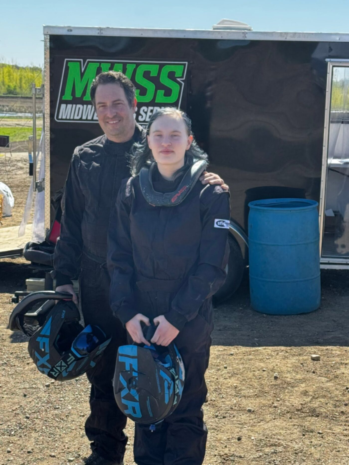 Lou and Lizzy with helmets, trailer in background